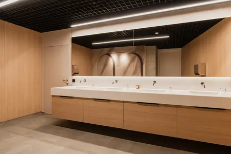 Wnętrze łazienki z drewnianymi meblami, nowoczesnym designem i minimalistycznym wykończeniem.