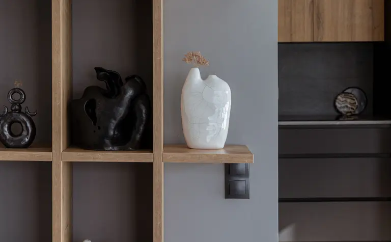 Minimalistyczne wnętrze z półkami i nowoczesnymi dekoracjami ceramicznymi.