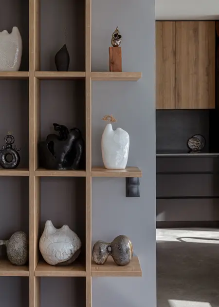 Minimalistyczne wnętrze z półkami i nowoczesnymi dekoracjami ceramicznymi.