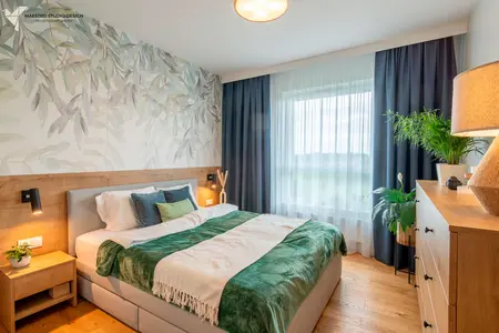 Wnętrze sypialni w stylu boho, nowoczesnym i współczesnym z zielonymi dodatkami.
