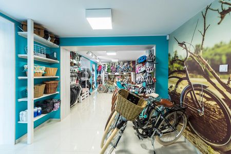 Garaż z rowerami, akcesoriami i niebieskimi ścianami w stylu boho.