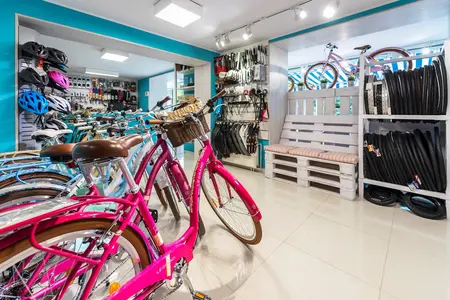 Sklep rowerowy z różowymi rowerami i akcesoriami, styl boho