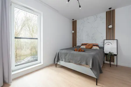 Wnętrze sypialni z szarym łóżkiem, marmurową ścianą, styl minimaluxe, nowoczesny i soft minimalizm.