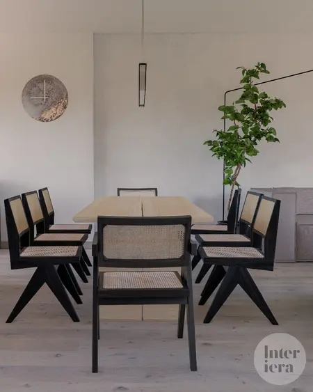 Jadalnia w stylu japandi i minimalistycznym z drewnianym stołem i czarnymi krzesłami.
