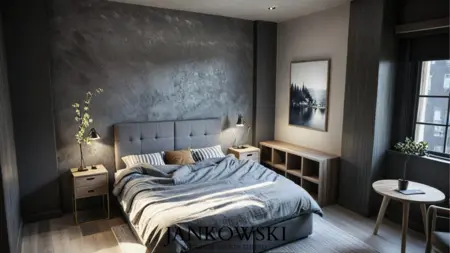 Sypialnia w stylu industrialnym i minimalistycznym z szarymi ścianami, drewnianymi meblami i lampą.