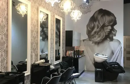 Wnętrze salonu fryzjerskiego z lustrami i glamour akcentami.