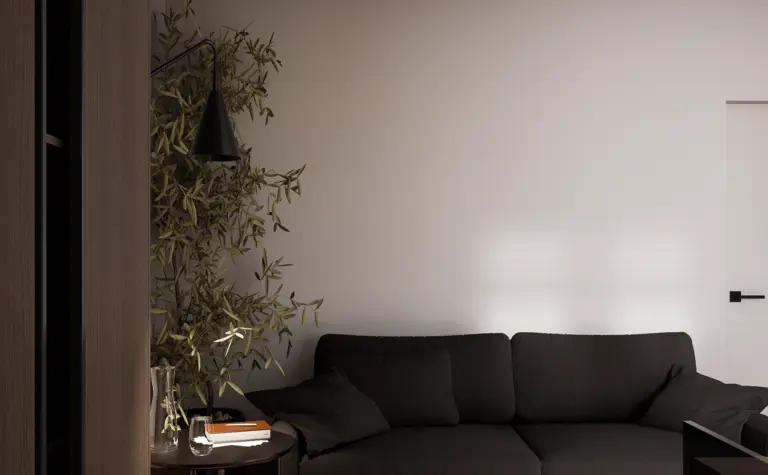 Wnętrze salonu w stylu minimalistycznym z ciemną sofą i drewnianą podłogą.