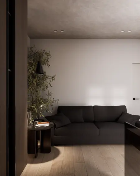 Wnętrze salonu w stylu minimalistycznym z ciemną sofą i drewnianą podłogą.