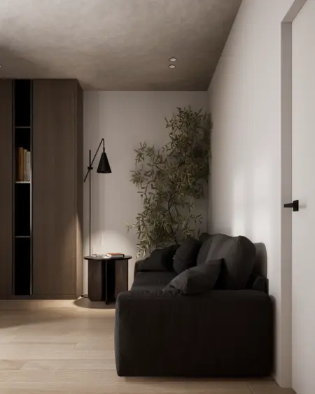 Wnętrze w stylu minimalistycznym z czarną sofą, drewnianymi meblami i roślinnością.