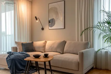 Wnętrze salonu w stylu boho z beżową sofą i rośliną