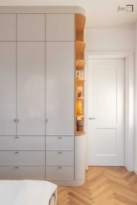 Eklektyczne wnętrze z szafą, drewnianą podłogą i detalami vintage.
