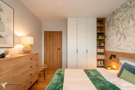 Wnętrze sypialni w stylu boho i nowoczesnym z drewnem i zielonymi dodatkami.