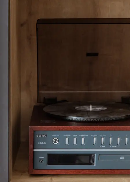 Gramofon TEAC na drewnianej półce w minimalistycznym, nowoczesnym wnętrzu.