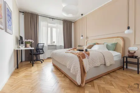 Wnętrze sypialni w stylu eklektycznym z biurkiem, łóżkiem i drewnianą podłogą.