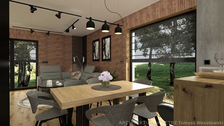 Wnętrze salonu w stylu industrialnym z drewnianym stołem, szarymi fotelami i ceglaną ścianą.