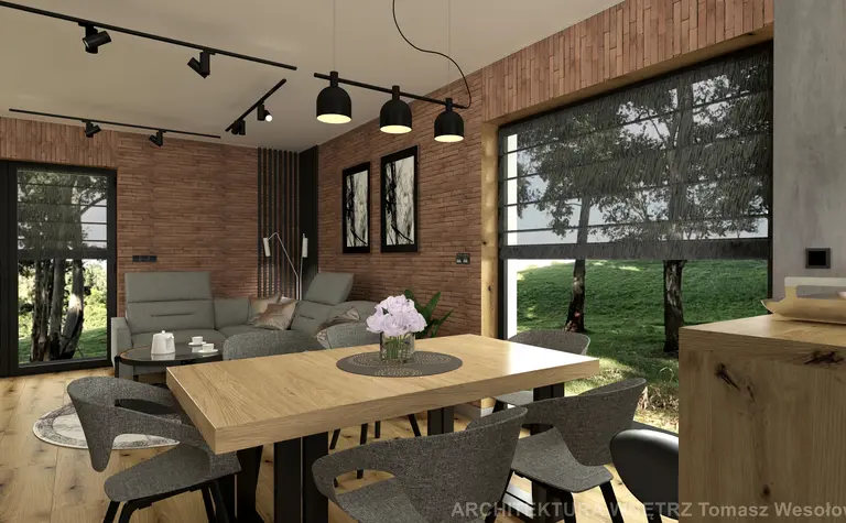 Wnętrze salonu w stylu industrialnym z drewnianym stołem, szarymi fotelami i ceglaną ścianą.