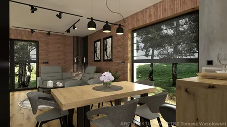 Wnętrze salonu w stylu industrialnym z drewnianym stołem, szarymi fotelami i ceglaną ścianą.