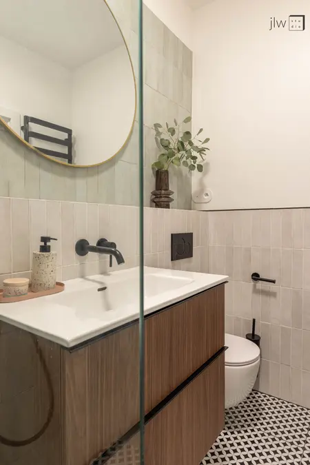 Wnętrze łazienki z elementami art deco i skandynawskimi, zielonymi kafelkami, vintage dodatkami.