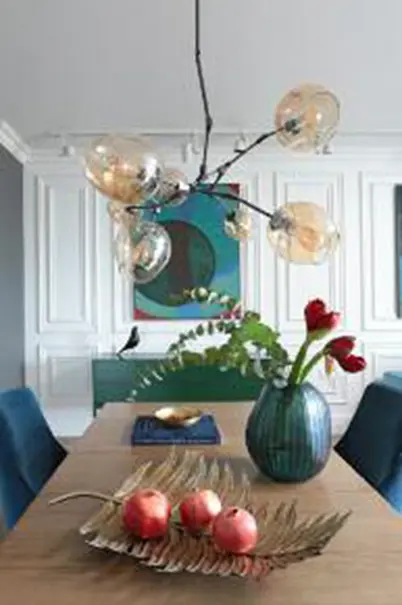 Jadalnia z minimalistycznym wystrojem, lampa i kwiaty w wazonie w stylu quiet luxury.