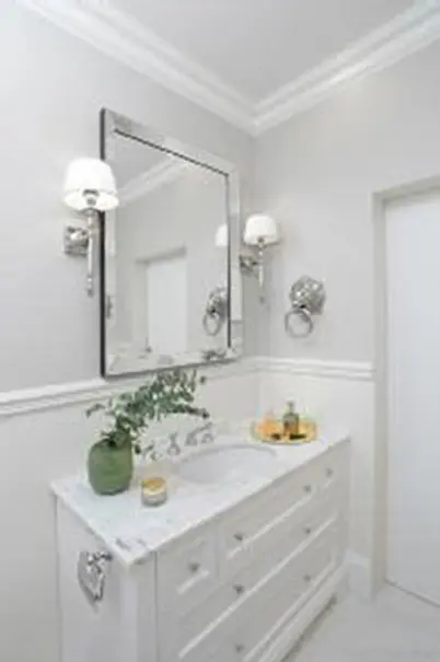 Wnętrze łazienki z białą umywalką, szarymi ścianami, style minimaluxe i quiet luxury.
