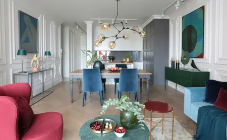 Wnętrze z zieloną komodą, niebieskimi krzesłami i roślinami - styl minimaluxe, quiet luxury.