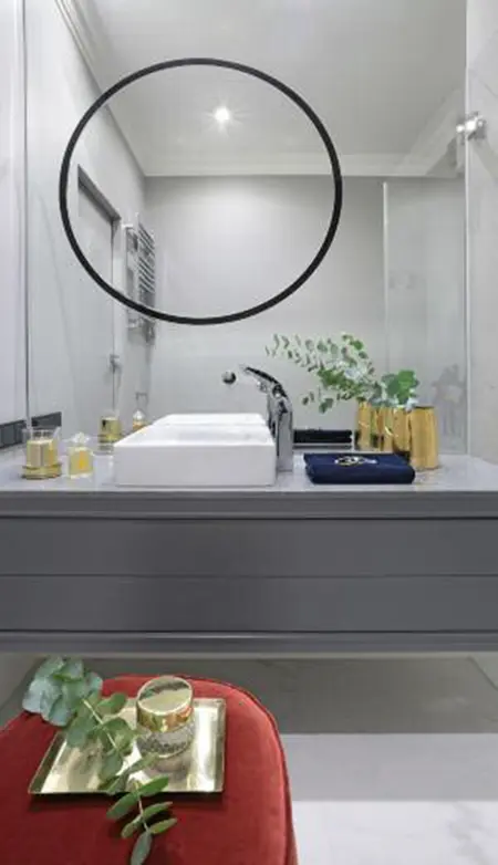 Nowoczesna łazienka z minimalistycznym designem, szarymi detalami i roślinnością.