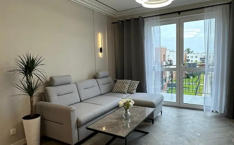 Wnętrze salonu z minimalistycznym wystrojem, nowoczesna sofa i stół.