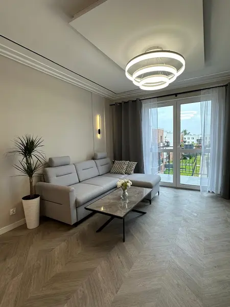 Wnętrze salonu z minimalistycznym wystrojem, nowoczesna sofa i stół.