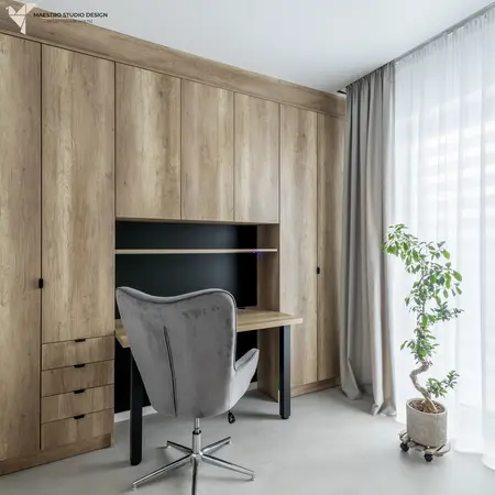 Wnętrze gabinetu z drewnianą zabudową, nowoczesnym biurkiem i rośliną. Styl minimalistyczny.
