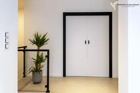 Przedpokój z białymi drzwiami, szarym podłogą i rośliną w doniczce, styl minimalistyczny, nowoczesny, glamour.