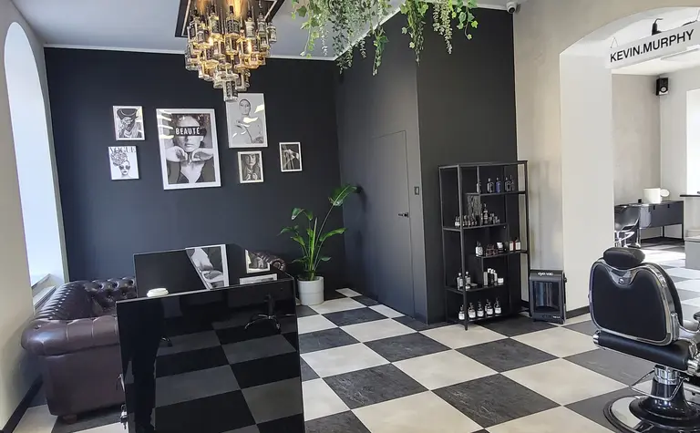 Wnętrze salonu fryzjerskiego z industrialnymi i nowoczesnymi elementami.
