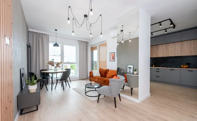 Wnętrze salonu w stylu industrialnym i minimalistycznym z brązową kanapą.