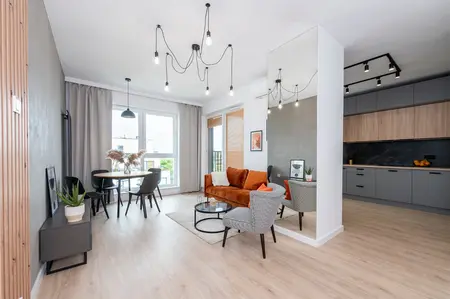 Wnętrze salonu w stylu industrialnym i minimalistycznym z brązową kanapą.