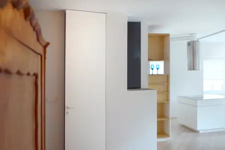 Wnętrze minimalistyczne z białymi meblami i drewnianymi detalami.