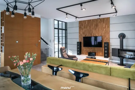 Wnętrze salonu w stylu industrialnym i minimalistycznym z drewnianymi elementami.