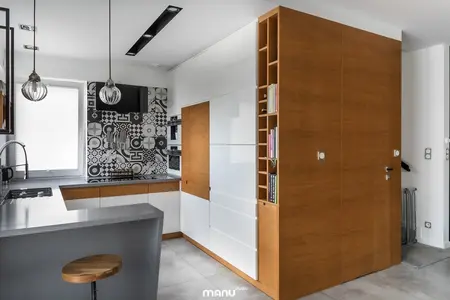 Kuchnia w stylu industrialnym z drewnianymi meblami i minimalistycznym wykończeniem.