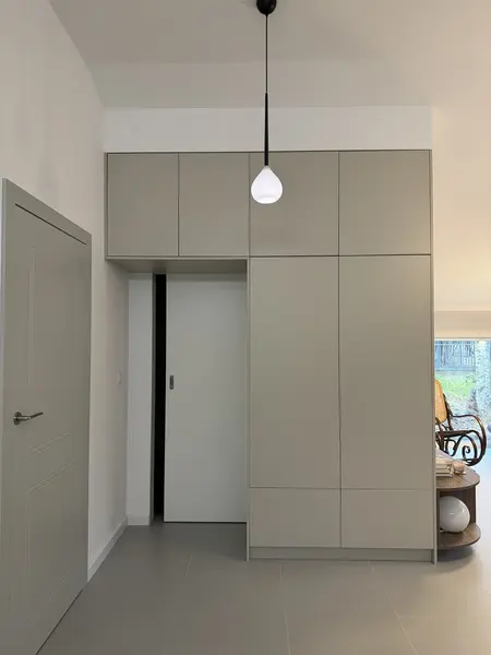 Przedpokój z minimalistyczną szafą, oświetleniem boho i rustykalnym akcentem.