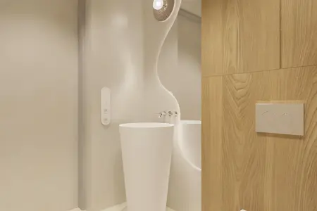 Nowoczesna łazienka w stylu japandi z białą umywalką i drewnianymi detalami.