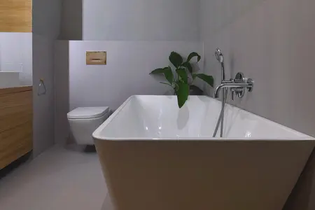 Nowoczesna łazienka boho z wanną, rośliną i minimalistycznymi detalami.