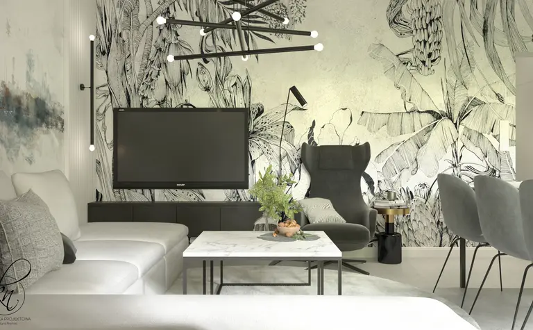 Salon z telewizorem, szaro-białą sofą i roślinnością w minimalistycznym stylu.