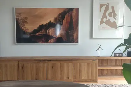 Wnętrze salonu w stylach boho, japandi, minimalistycznym z drewnianą komodą.