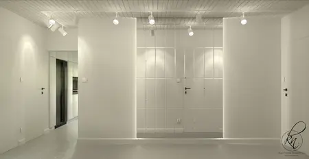 Minimalistyczne wnętrze z białymi ścianami i czarnymi akcentami.