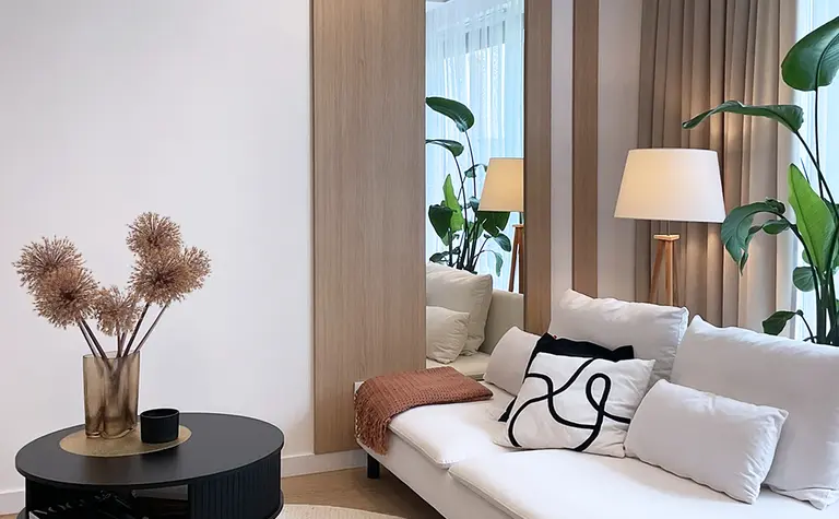 Wnętrze salonu w stylu glamour i minimalistycznym z roślinami.