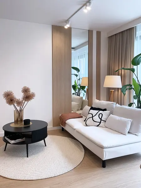 Wnętrze salonu w stylu glamour i minimalistycznym z roślinami.