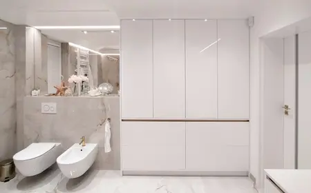 Nowoczesna łazienka glamour z białymi meblami i złotymi detalami.