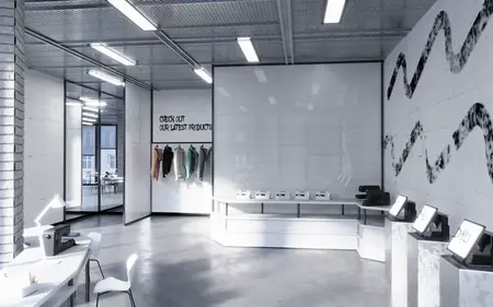Wnętrze biura z minimalistycznym designem, białymi meblami i nowoczesnym oświetleniem.
