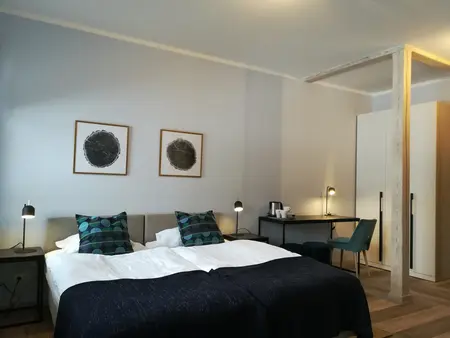 Sypialnia z minimalistycznym wystrojem, nowoczesnymi meblami i współczesnymi akcentami.