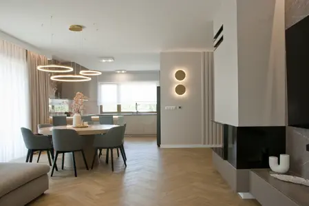 Jadalnia z okrągłym stolikiem, szarymi krzesłami, minimalistyczny styl, nowoczesny design.
