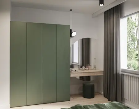 Eklektyczna sypialnia z minimalistycznymi meblami, zieloną szafą i nowoczesnym biurkiem.
