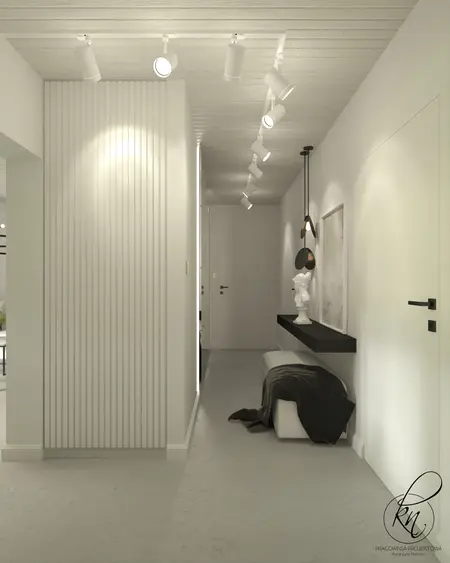 Przedpokój w stylu minimalistycznym z białymi ścianami i czarnymi detalami.